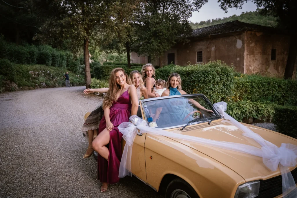 Amiche della sposa sull'auto d'epoca decorata