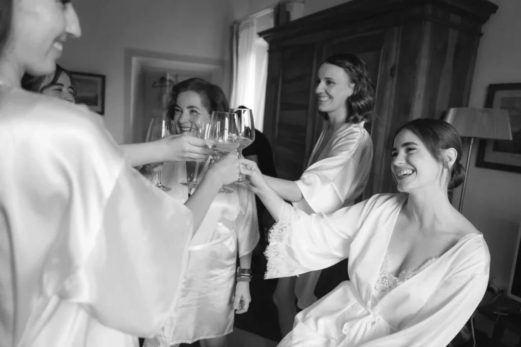 La sposa brinda con le amiche durante i preparativi, in bianco e nero
