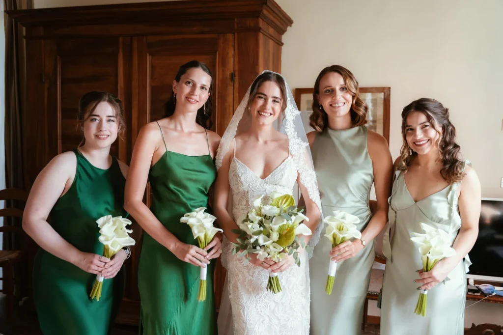 La sposa con le damigelle in abiti verdi e bouquet di calle