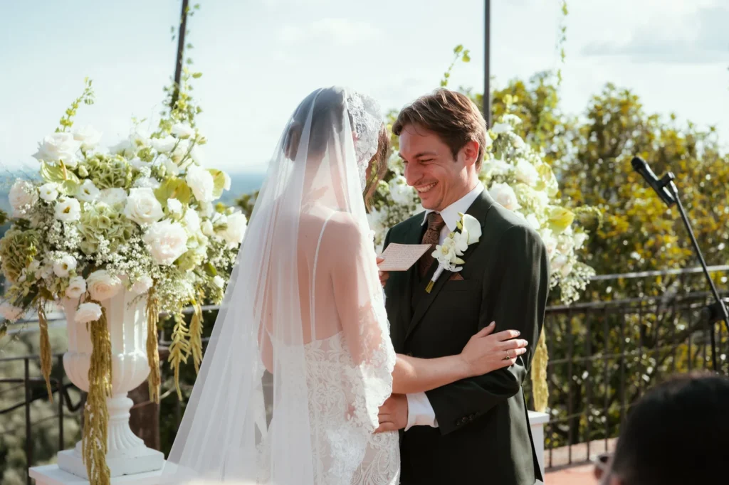 Lo sposo sorride alla sposa velata durante il rito