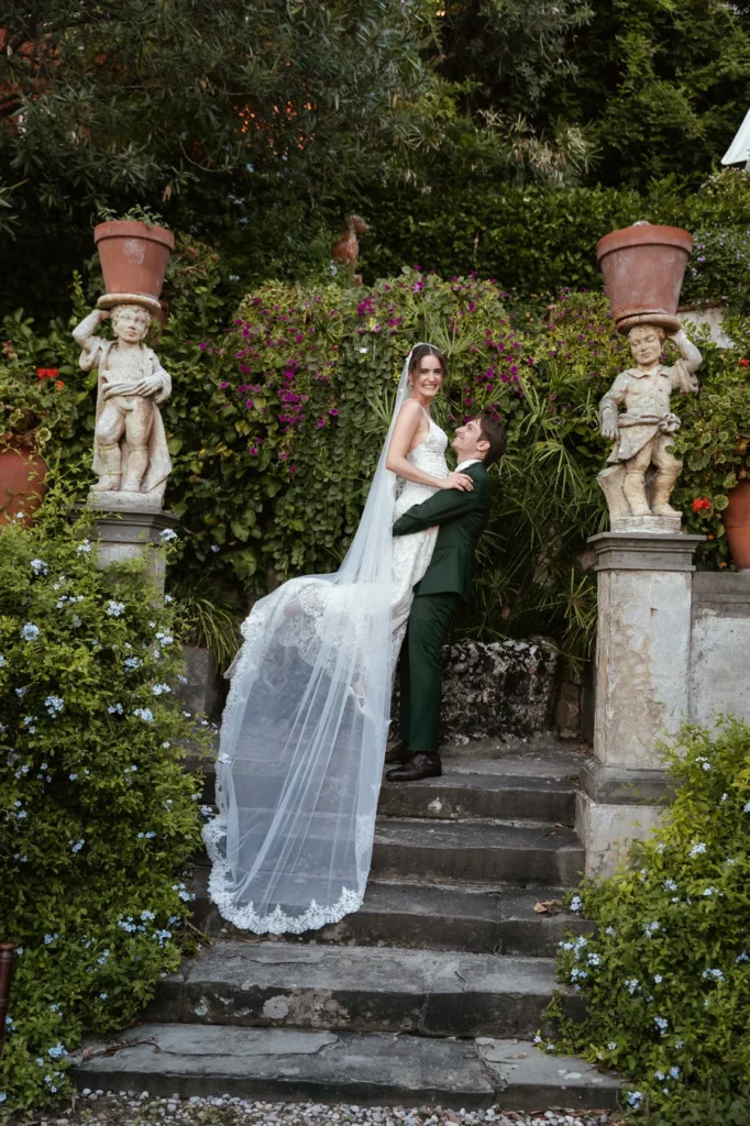 Gli sposi abbracciati sulla scalinata del giardino tra le statue