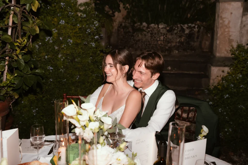 Gli sposi sorridenti al tavolo durante la cena