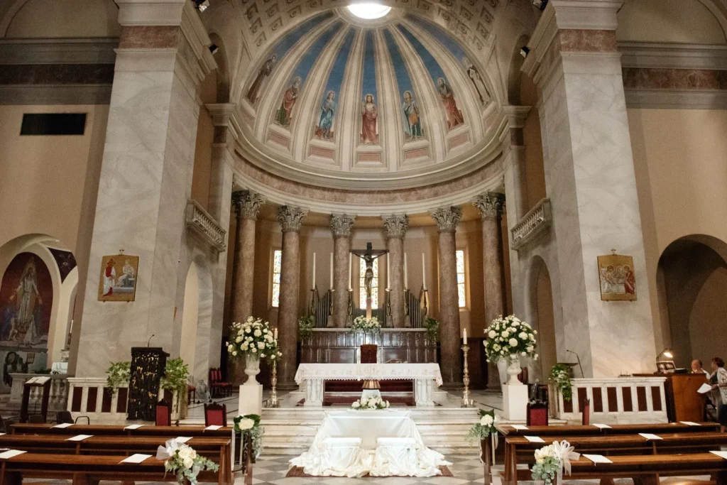 Interno di una chiesa con l'altare decorato di fiori bianchi
