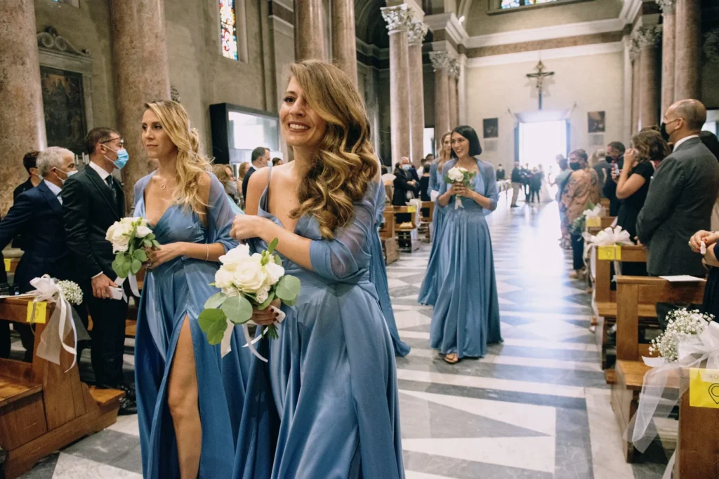 Damigelle in azzurro lungo la navata della chiesa