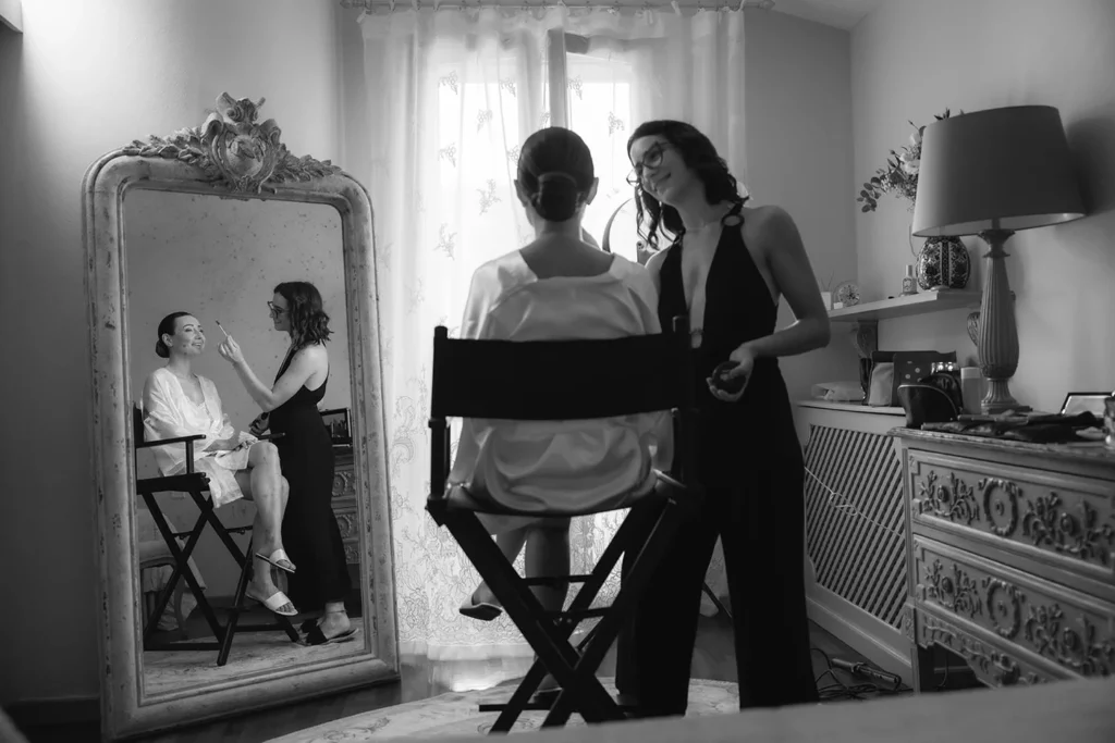 La sposa al trucco riflessa nello specchio, in bianco e nero