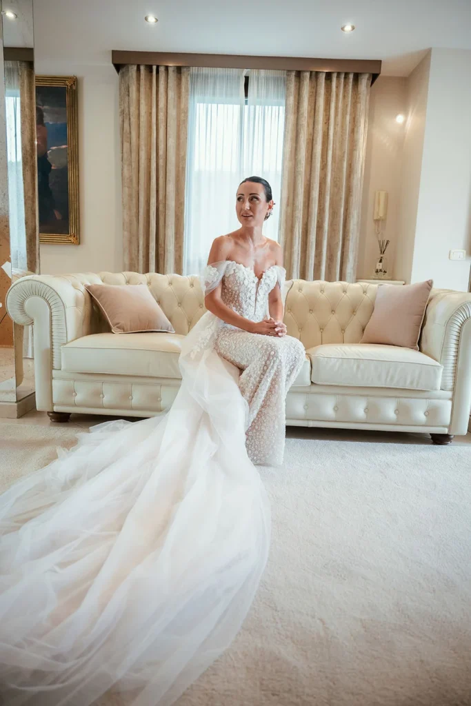 La sposa seduta sul divano con il lungo strascico