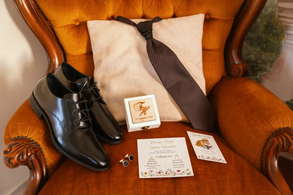 Scarpe e cravatta dello sposo sulla poltrona