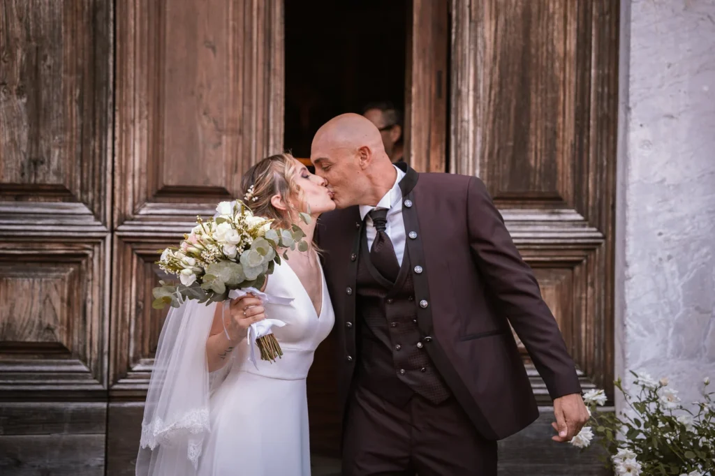 Il bacio degli sposi davanti al portone