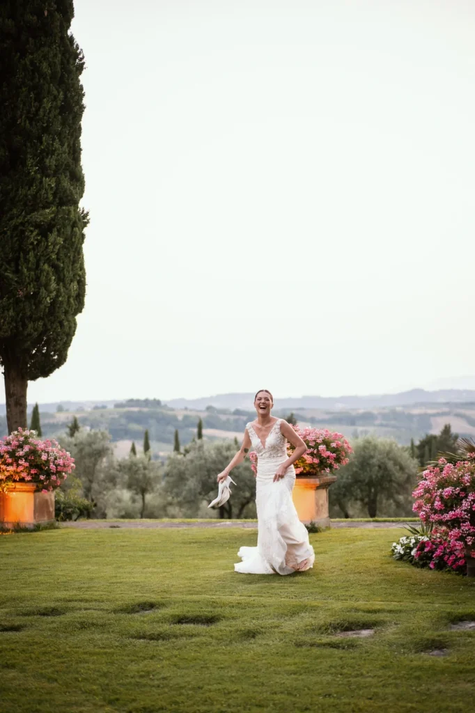 Sposa che cammina sul prato di una villa tra i fiori
