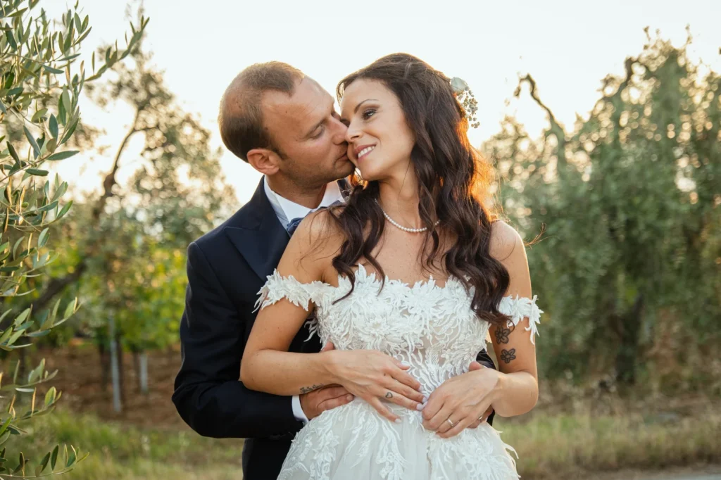 Sposo che abbraccia la sposa tra i filari