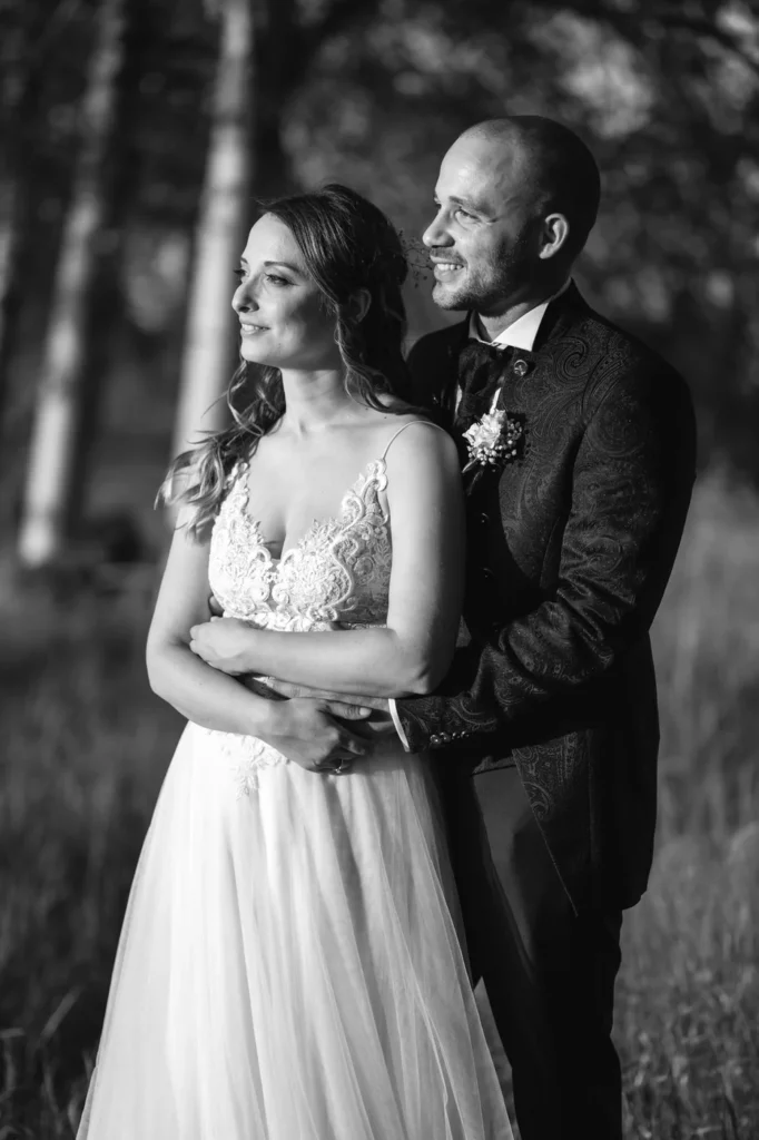 Sposo che abbraccia la sposa da dietro, in bianco e nero