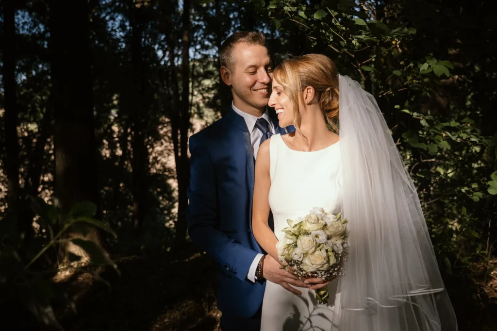 Sposi abbracciati nel bosco con il bouquet
