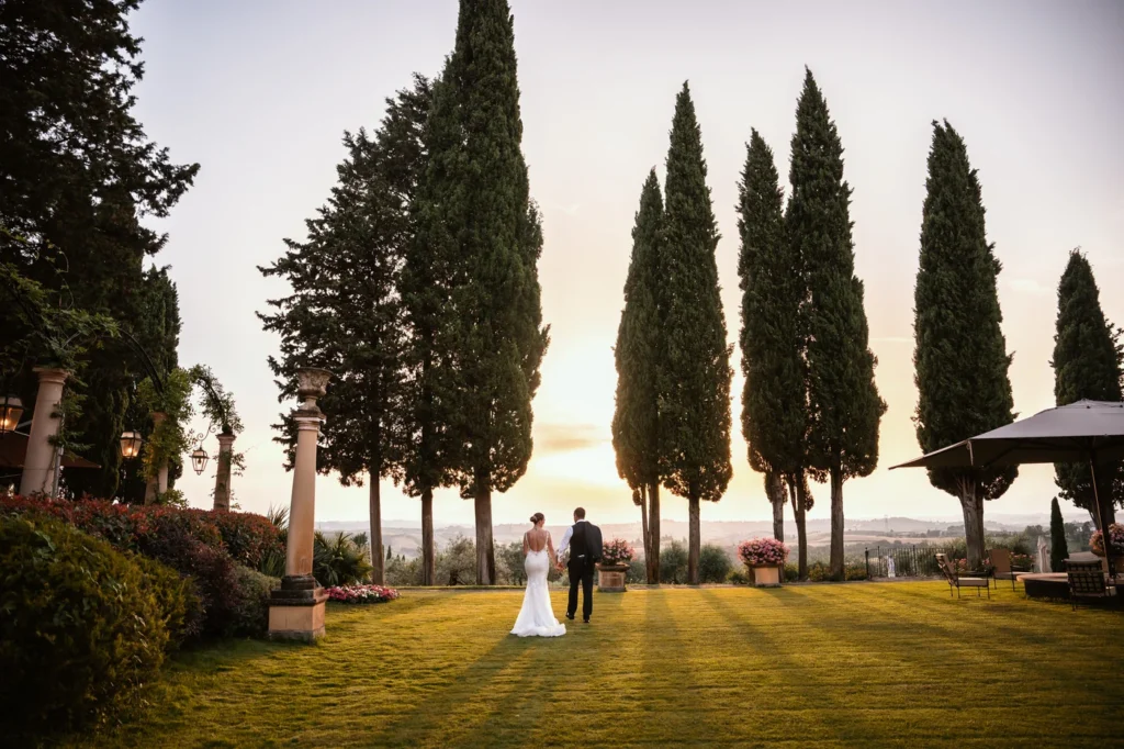 Sposi tra i cipressi di una villa al tramonto