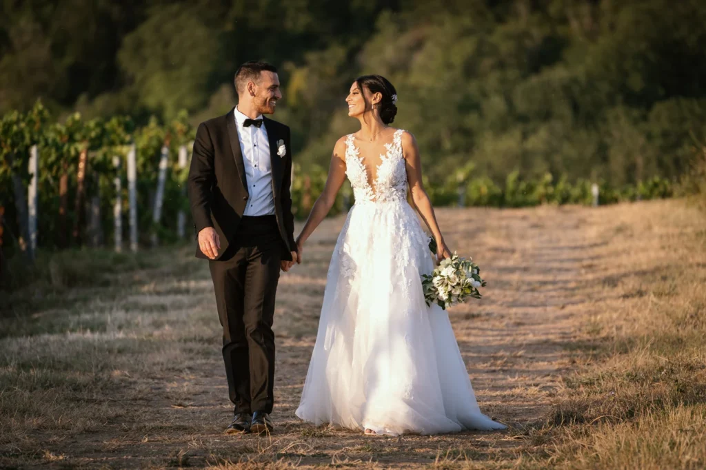 Sposi che camminano su un sentiero tra le vigne