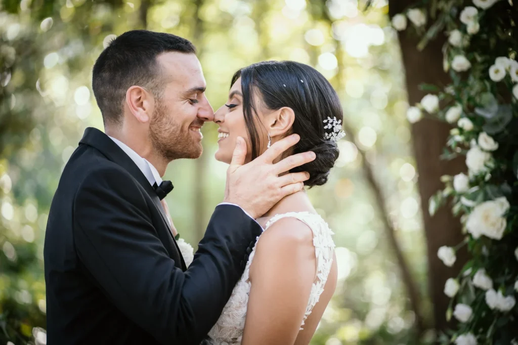 Sposi vicinissimi tra le rose bianche
