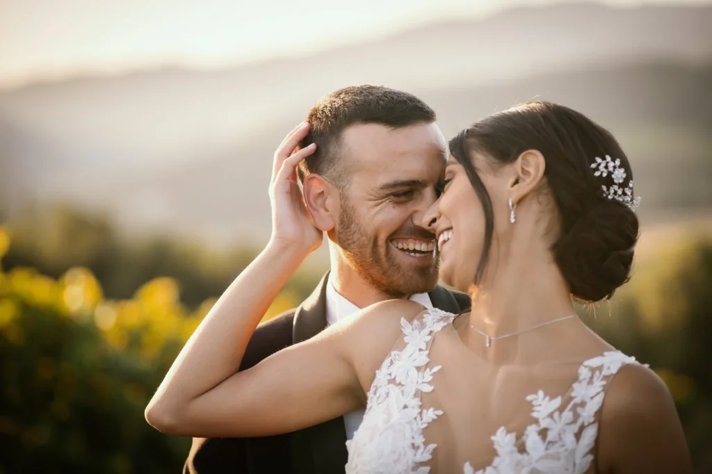 Sposi che si sorridono vicini nella luce calda del tramonto