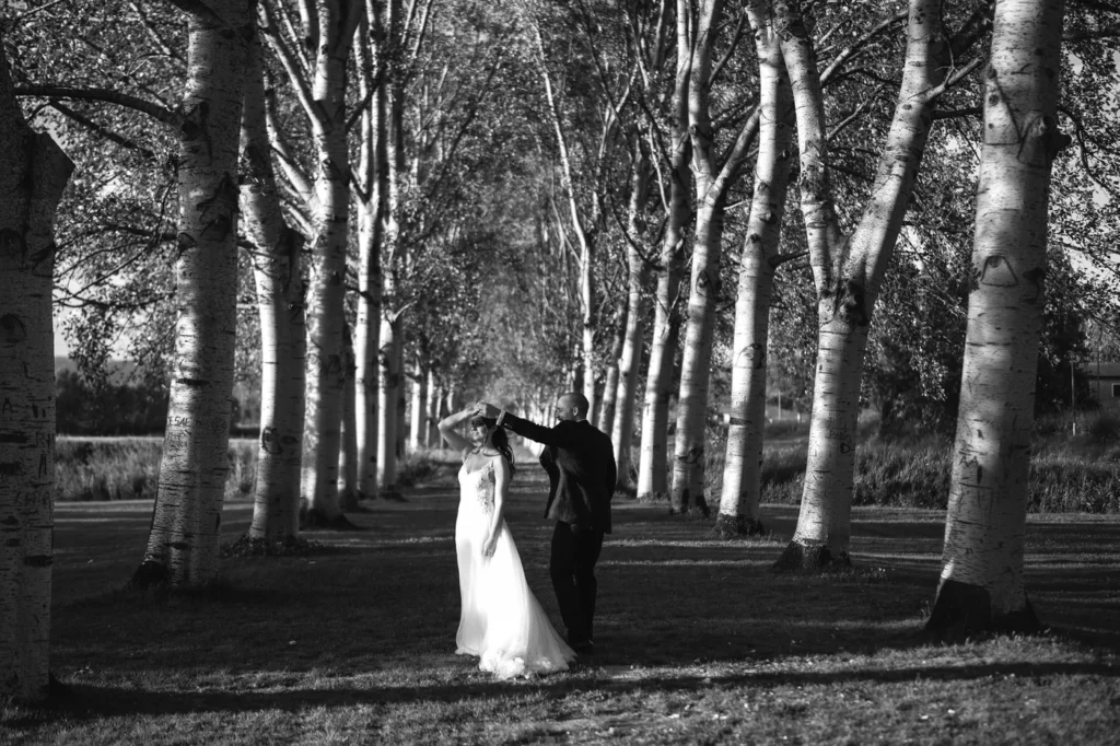 Sposi che ballano in un viale di alberi, in bianco e nero