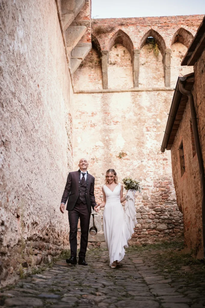 Sposi che camminano in un vicolo di pietra