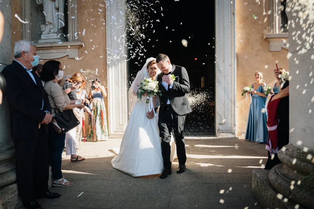 Sposi all'uscita della chiesa sotto il lancio del riso